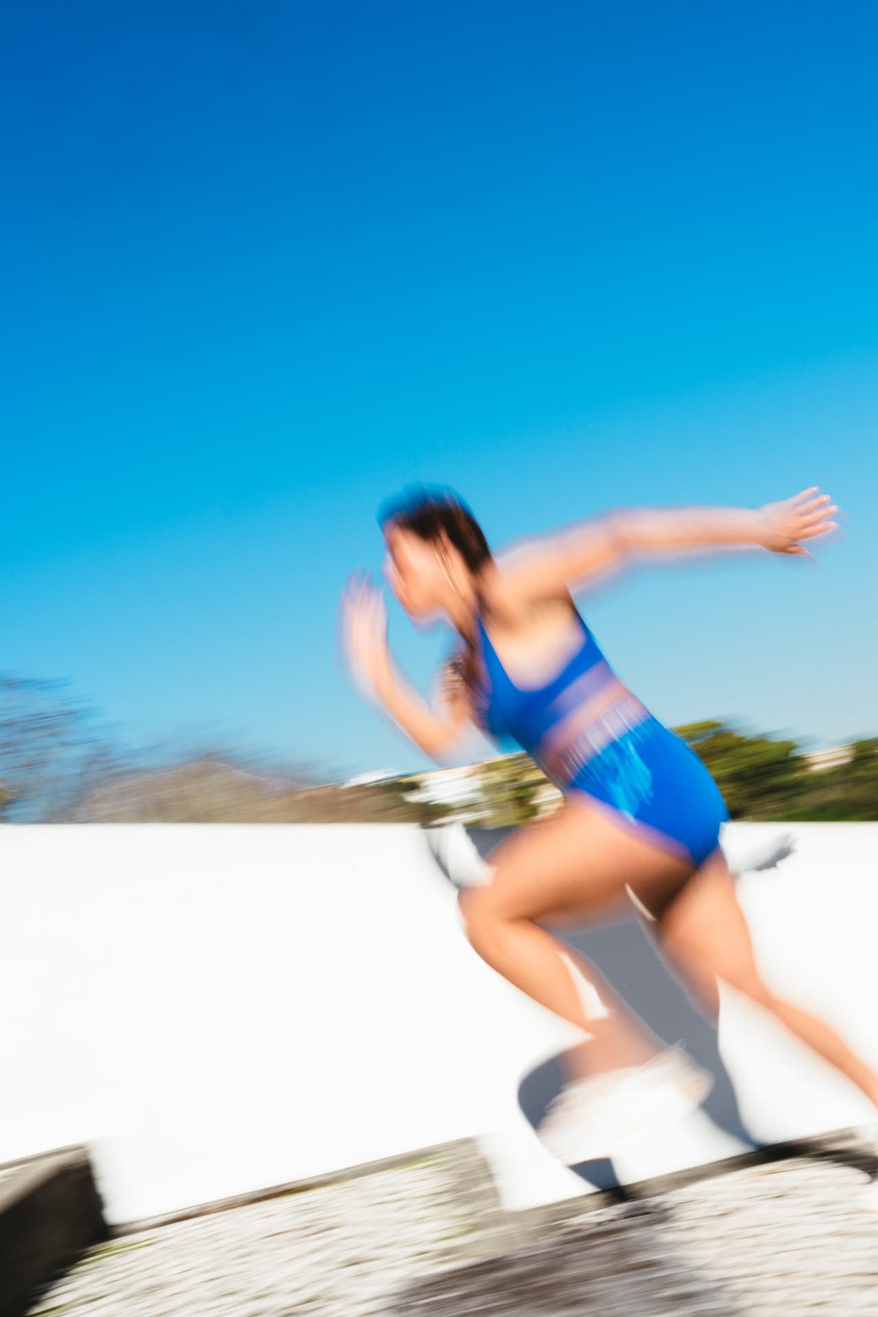 Athlète courant en mouvement, flou artistique sous un ciel bleu